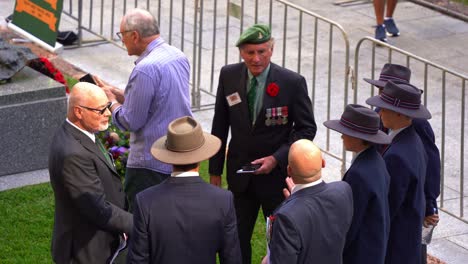 Sergeant-Kev-Horton-shares-stories-with-the-younger-generation-of-Australians-at-Anzac-Square,-fostering-camaraderie-and-passing-down-traditions-of-remembrance-and-respect-on-Anzac-Day