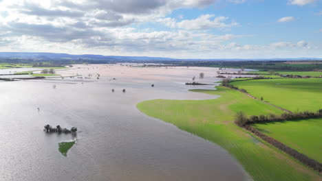 Wide-aerial-trucking-view-of-inundated-agricultural-land-by-flood,-Somerset,-UK