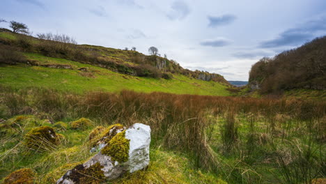 Timelapse-of-rural-nature-farmland-with-rock-stone-in-grass-field-during-cloudy-day-viewed-from-Carrowkeel-in-county-Sligo-in-Ireland