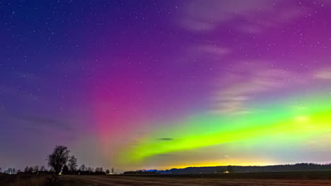 Timelapse-shot-of-Northern-lights-Polar-Aurora-Borealis-dancing-over-rural-landscape-at-night-time
