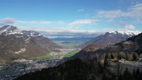 Schweizer-Stadt-Liegt-Tief-In-Einem-Grasbedeckten-Tal-Unter-Schneebedeckten-Bergen