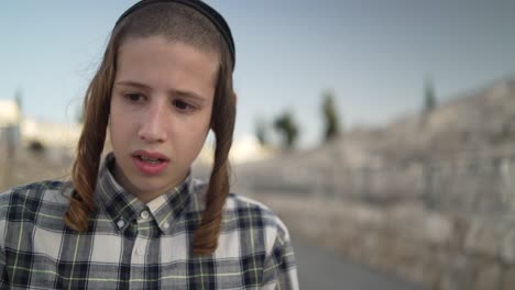 a-jewish-12-year-old-boy-walking-in-har-hamenuchot-cemetery-to-his-fathers-grave,-close-up-shot