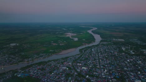 Arauca,-colombia-at-dusk,-showing-the-river-and-urban-landscape,-aerial-view