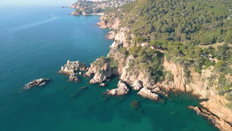 Bestaunen-Sie-Die-Atemberaubenden-Ausblicke-Von-Lloret-De-Mar-Aus-Der-Luft,-Mit-Dem-Ruhigen-Blauen-Wasser-Und-Den-Luxus-Touristenzentren-Santa-Cristina-Und-Cala-Treumal-Entlang-Der-Mittelmeerküste