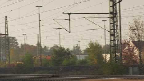 Eisenbahnlinien-Laufen-In-Der-Abenddämmerung-Inmitten-Eines-Labyrinths-Aus-Stromkabeln-Zusammen,-Industrielle-Atmosphäre