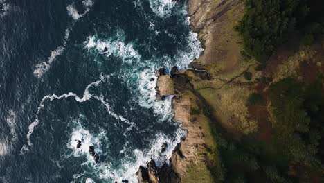 Bird's-eye-view-flying-over-rugged-Oregon-coastline-along-Pacific-Ocean