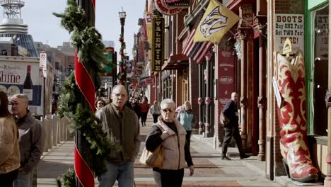 Tourists-on-Broadway-Street-in-Nashville,-Tennessee-during-the-day-with-wide-video-stable-in-slow-motion