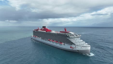 Virgin-cruise-ship-in-open-sea-close-to-Puerto-Plata-coast-in-Dominican-Republic,-aerial-drone-circling-view