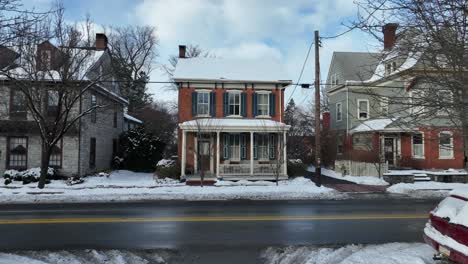 Aerial-establishing-shot-of-a-brick-house-with-snow