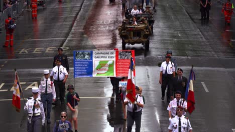 Veterans-with-Campagne-de-Gallipoli-banner-marching-down-the-street-in-the-traditional-Anzac-Day-parade,-paying-tribute-to-those-who-served-in-the-war