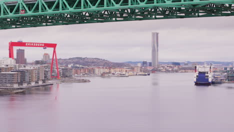 Aerial-under-Alvsborg-bridge-over-Gota-Alv-with-view-of-iconic-Eriksberg-crane