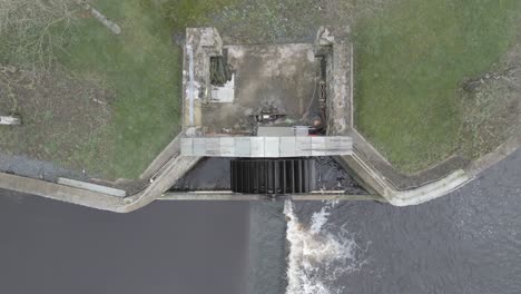 A-hydroelectric-plant-on-a-river-in-ballinodre,-ireland,-showcasing-sustainable-energy,-aerial-view
