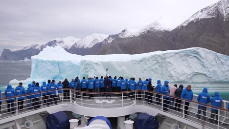 Kreuzfahrtpassagiere-Auf-Dem-Vorderdeck-Vor-Einem-Riesigen-Eisberg-Im-Fjord,-Zeitlupe