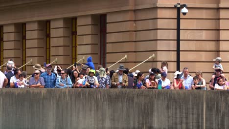 Australian-families-lined-up-on-the-sky-bridge-above-Adelaide-street,-waiting-for-the-commencement-of-annual-Anzac-day-parade-tradition