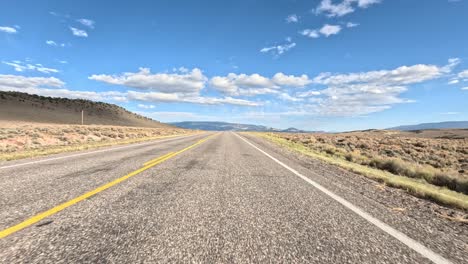 Hyperlapse-Fahrt-Durch-Die-Wüstenlandschaft-Von-Utah-Mit-Blauem-Himmel-Und-Flauschigen-Weißen-Wolken-An-Einem-Sonnigen-Tag