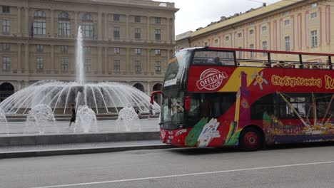 Clip-Panorámico-De-Un-Autobús-Turístico-Rojo-Estacionado-En-La-Plaza-De-Italia,-Frente-A-Famosas-Fuentes-De-Agua-Y-Hermosos-Edificios-Tradicionales