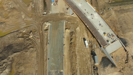 Top-down-view-of-road-construction-with-an-overpass-and-heavy-machinery