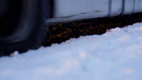 Cars-driving-though-slush-snow-during-snowfall---Close-up