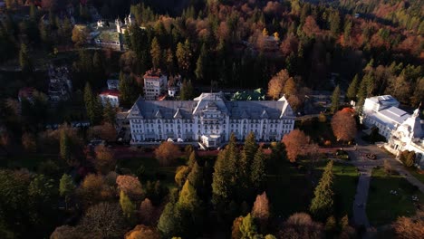 Autumnal-aerial-view-of-the-Palace-Hotel-in-Sinaia-with-surrounding-fall-foliage