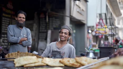 Toma-Cinematográfica-En-La-Calle,-Un-Hermano-Está-Preparando-Una-Tortilla-Fría-En-Una-Rejilla-Fría-Y-Mirando-A-La-Cámara