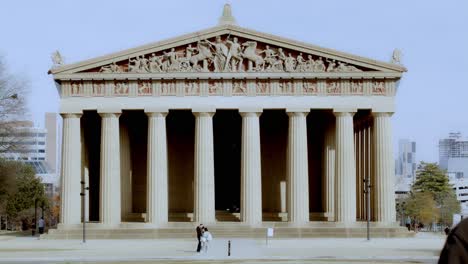 The-Partehnon-building-in-Nashville,-Tennessee-close-up-with-man-walking-towards-camera