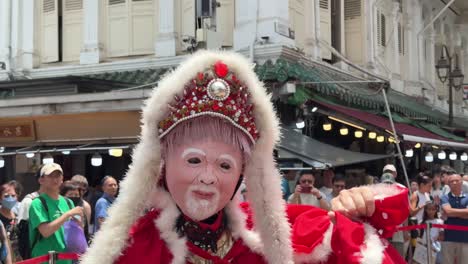 Tourists-are-fascinated-by-the-face-or-mask-changing-performance-in-Chinatown,-Singapore