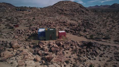 Eine-Drohne,-Die-Um-Ein-Einzigartiges-Farbenfrohes-Architektonisches-Gebäude-In-Der-Joshua-Tree-Wüste-Kreist