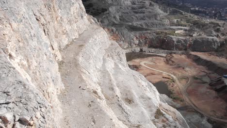 Aerial-view-old-abandoned-quarry-steps-industry-tilt-down-sunny-day