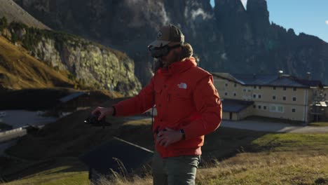 Male-Wearing-Orange-Jacket-Wearing-FPV-Goggles-And-Holding-Drone-In-Launch-Preparing-For-Launch