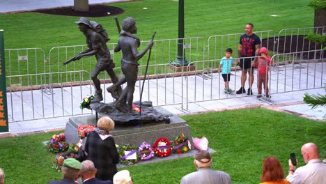 Veterans-and-families-gathered-around-bronze-sculpture-of-the-South-West-Pacific-Campaign,-paying-homage-to-those-who-sacrifice-during-the-war-at-Brisbane's-Anzac-Square