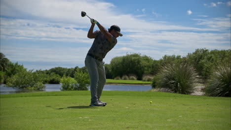 Slow-motion-of-a-latin-mexican-golfer-wearing-an-adidas-grey-outfit-driving-swinging-hitting-the-ball-hard-at-the-teeing-ground