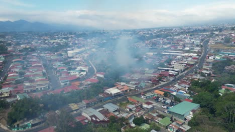 Disparo-De-Drone-Alejándose-Del-Humo-Causado-Por-El-Fuego-Con-Cenizas-Volando-Hacia-La-Cámara