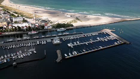 Faro-En-La-Playa,-Pequeño-Puerto-Con-Muchos-Barcos,-Hermosa-Playa-Con-Olas-Cerca-De-Una-Pequeña-Ciudad,-Mar-Báltico,-Warnemünde,-Drone