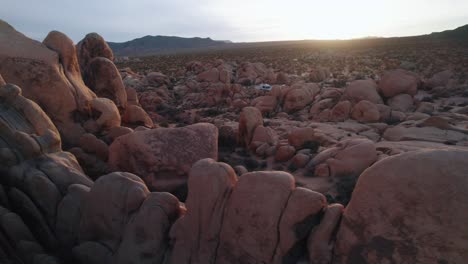 Drone-flying-between-rugged-steep-rock-formations-in-Joshua-Tree-National-Park-at-sunset