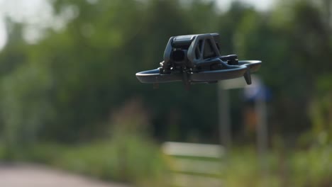 Close-up-of-DJI-Avata-FPV-drone-quadcopter-flying-in-a-park