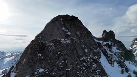 Snow-capped-Ciucas-Mountains-under-blue-sky,-rugged-peaks,-drone-footage,-daylight