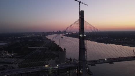 Gordie-Howe-International-Bridge-under-construction-during-sunset,-aerial-drone-view