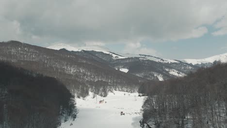 Eine-Drohnenaufnahme-Von-Waldbergen-Mit-Schnee,-Warmes-Wetter,-4K-Video-Zum-Vorwärtsfliegen,-Europäische-Winternatur