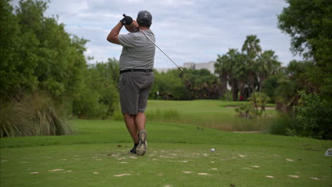 Zeitlupe-Eines-übergewichtigen-Lateinamerikanischen-Golfers-In-Grauer-Kleidung,-Der-Auf-Einem-Golfplatz-Einen-Übungsschwung-Macht
