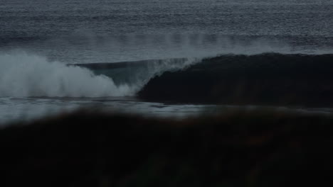 Tracking-pan-follows-perfect-wave-breaking-left-as-mist-rises-above-over-back