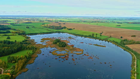 Freshwater-lake-island-formations-rural-nature-agriculture-fields-aerial-drone