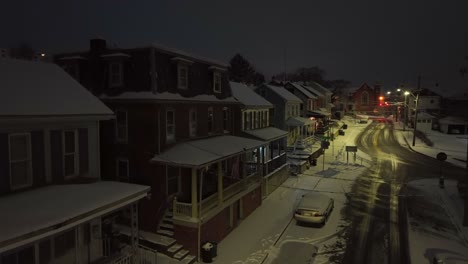 Houses-and-Jeep-covered-in-snow-at-night-in-small-town-USA