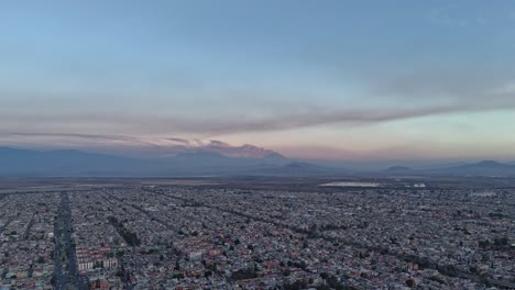 Vista-Aérea-De-Hiperlapso-De-Ecatepec,-Con-Los-Volcanes-Al-Fondo,-Ciudad-De-México.