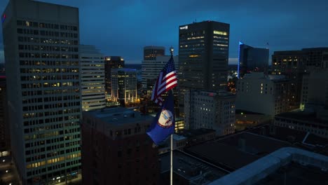 American-flag-and-Virginia-flag-waving-in-front-of-Richmond-skyline-at-night
