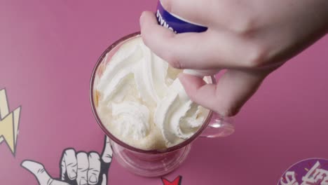 Spraying-whipped-cream-over-a-vanilla-milkshake