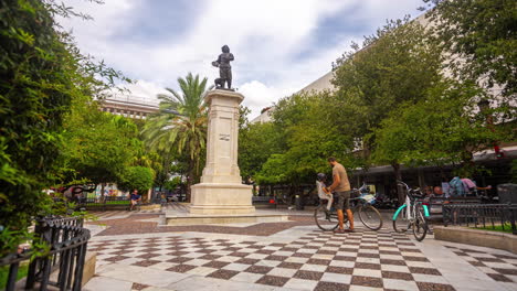 People-hanging-around-square-statue,-city-lifestyle-on-a-warm-summer-day-in-Seville,-Spain