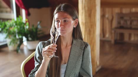 Junge-Kaukasische-Frau-Trinkt-Champagner-Am-Esstisch-Im-Restaurant