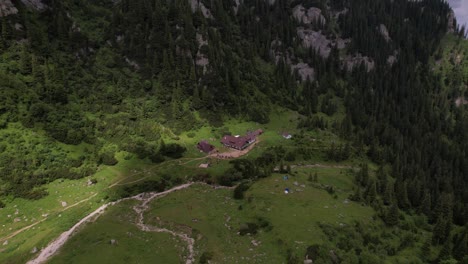 Malaiesti-chalet-nestled-in-lush-bucegi-mountains-on-a-cloudy-day,-aerial-view