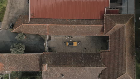 Aerial-top-View-of-Yellow-Car-in-Old-Courtyard