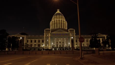 Arkansas-state-capitol-in-Little-Rock-Arkansas-at-night-with-holiday-lights-on-the-building-and-vehicles-driving-by-with-medium-shot-video-stable